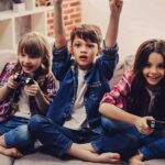 Cheerful kids are sitting together on sofa at home | Techlog.gr - Χρήσιμα νέα τεχνολογίας