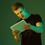 playing with tablet caucasian man s portrait isolated green studio background neon light | Techlog.gr - Χρήσιμα νέα τεχνολογίας